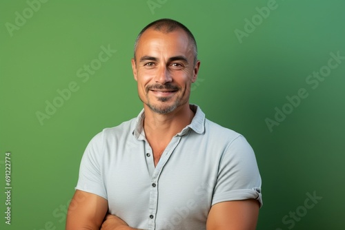 Portrait of a smiling middle-aged man against a green background