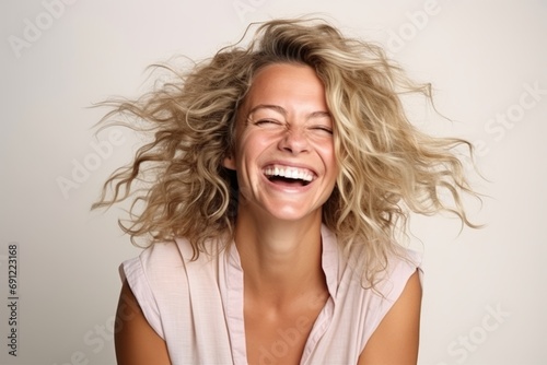 Beautiful young woman laughing with her hair blowing in the wind. photo