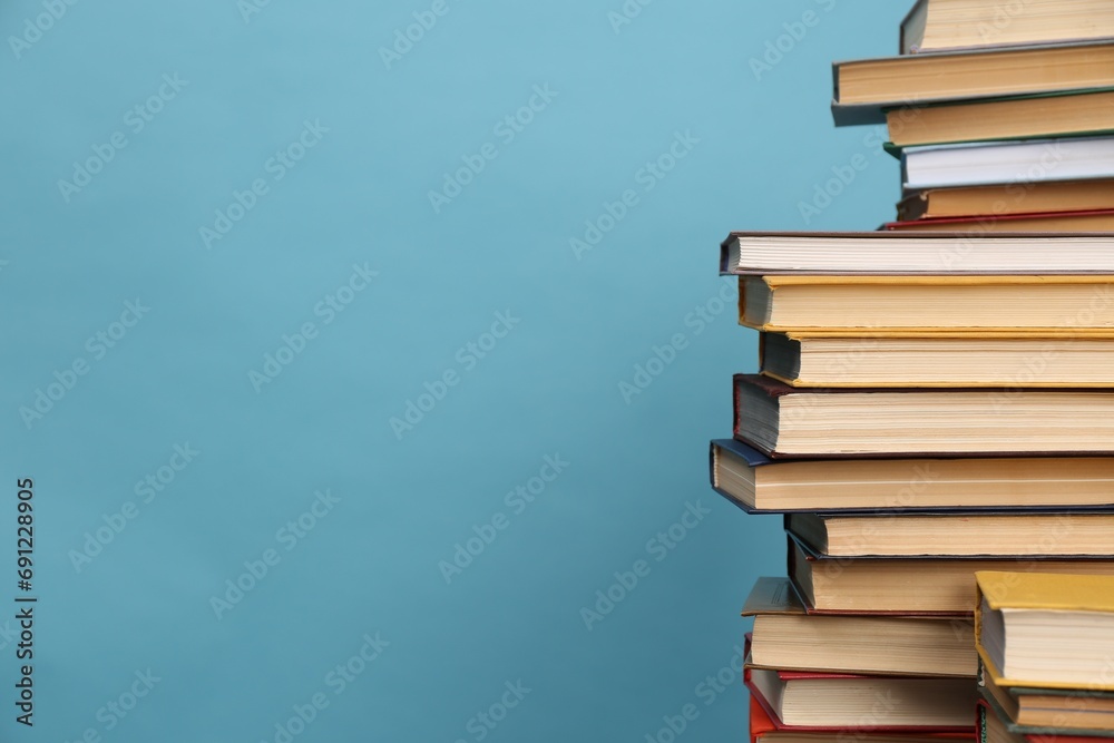 Many hardcover books on turquoise background, space for text. Library ...