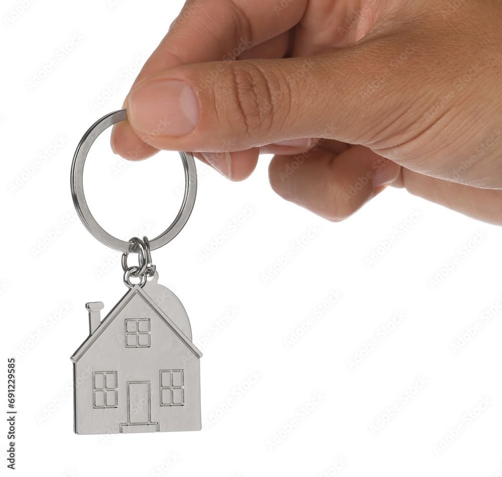 Woman holding metallic keychain in shape of house on white background, closeup Woman holding metallic keychain in shape of house on white background, closeup