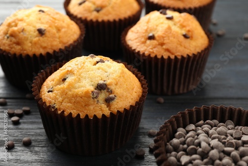 Delicious freshly baked muffins with chocolate chips on dark gray table, closeup