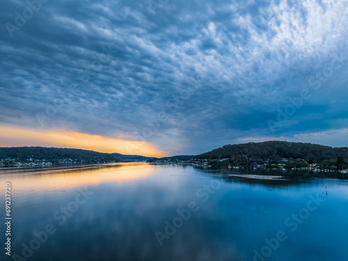 Heavy cloud covered sunrise over the bay with colour and reflections