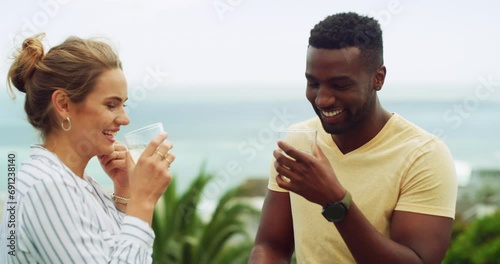 Toast, drinks and couple on holiday at ocean resort, hotel or celebration of interracial marriage. Smile, cheers and wine, happy man and woman on island vacation with love, travel and beach terrace. photo