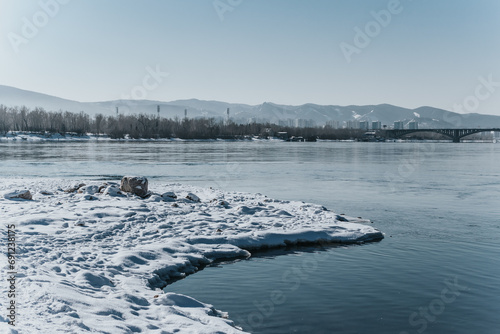 Landscape: stones covered with snow on the banks of the Yenisei