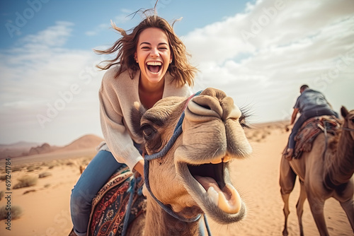 Fototapet Happy tourist having fun enjoying group camel ride tour in the desert