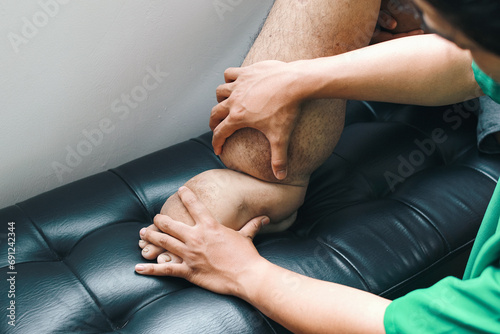 Doctor examining foot patient that suffering from edema, filariasis or lymphatic filariasis on sofa at the hospital