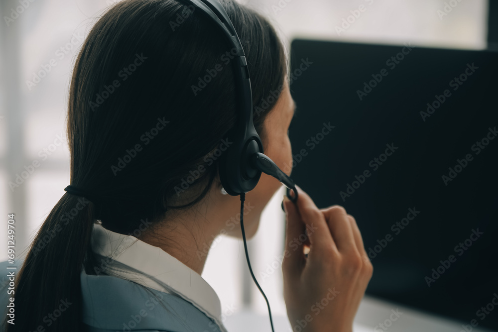 Beautiful female call center operator working on computer in office Beautiful female call center operator working on computer in office