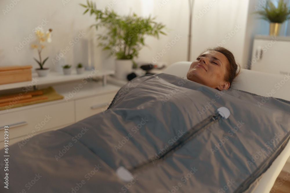 woman doing whiskey swaddling procedure in thermal blanket