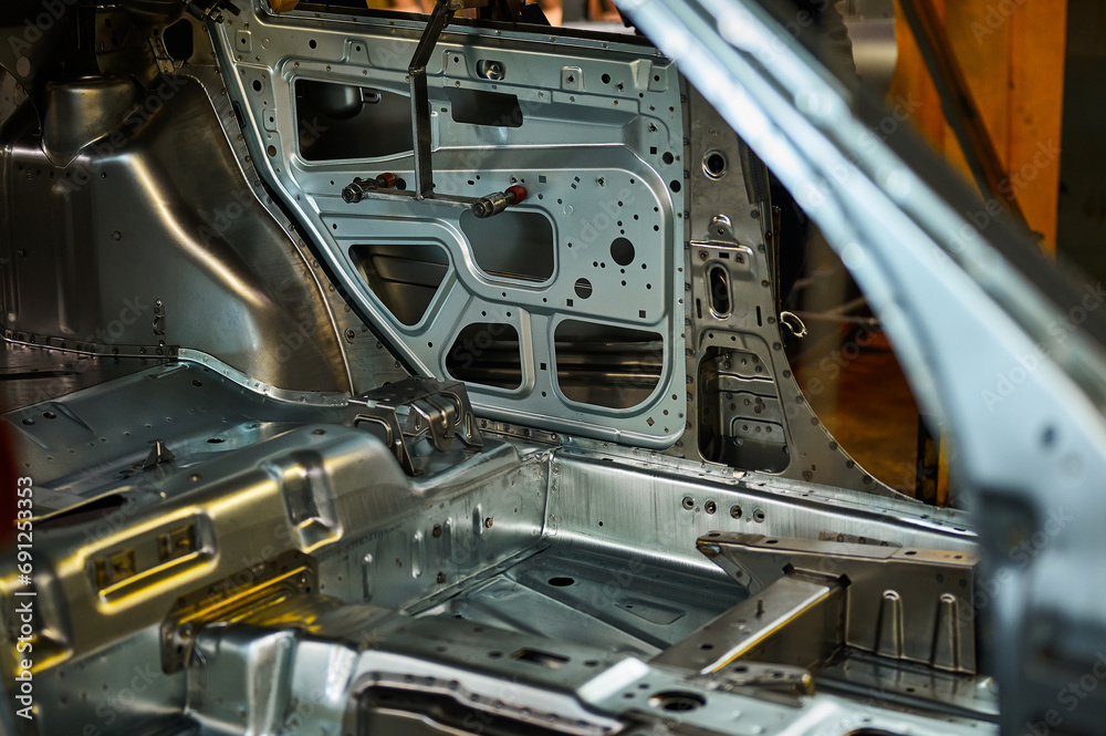 Shiny metal car body element in assembling workshop