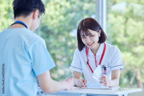 病院内にて打ち合わせを行う看護師の男女 photo