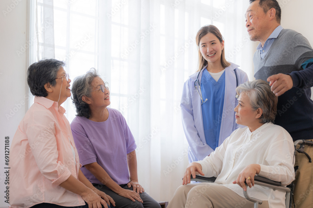 Asian young nurse support couple senior older man and woman in a wheelchair. elderly mature and a group of senior friends living in the hospital. socializing of retired people.