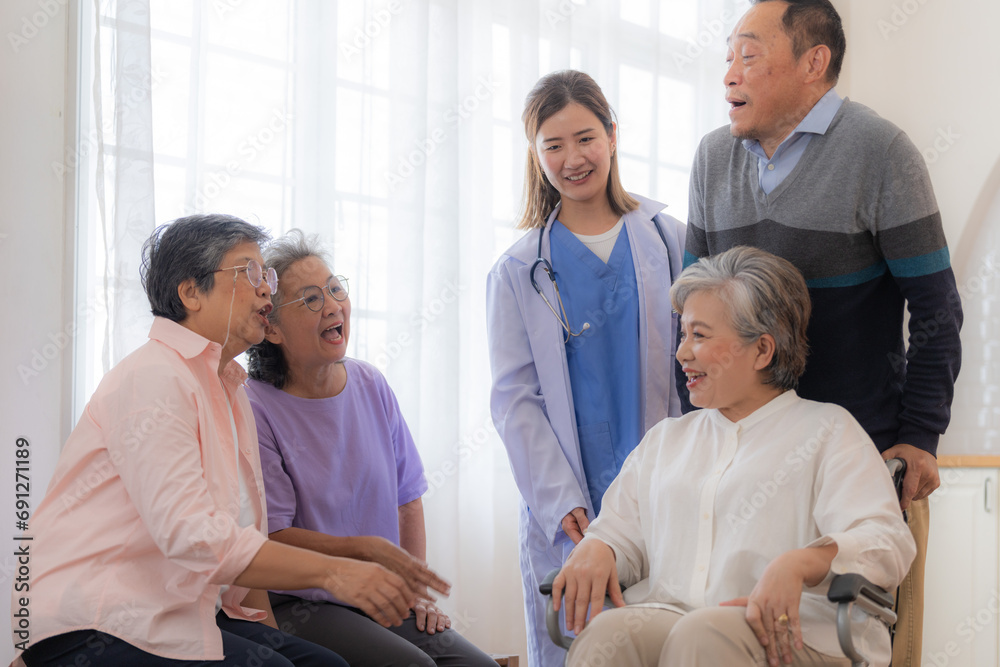 Asian young nurse support couple senior older man and woman in a wheelchair. elderly mature and a group of senior friends living in the hospital. socializing of retired people.