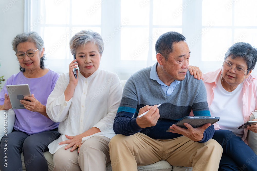 Happiness of the group females and male elderly talking with Video Call from smart tablet. Senior people are talking and enjoy together at the living room. Joyful retired friends enjoying relaxation. Happiness of the group females and male elderly talking with Video Call from smart tablet. Senior people are talking and enjoy together at the living room. Joyful retired friends enjoying relaxation.