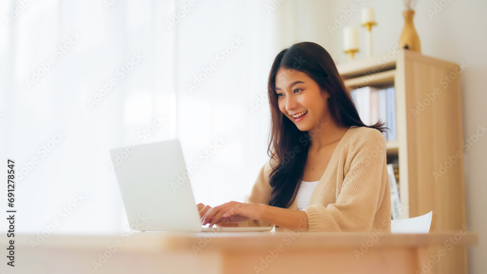 Funny euphoric young asian woman celebrating winning or getting ecommerce shopping offer on computer laptop. Excited happy girl winner looking at notebook celebrating success Funny euphoric young asian woman celebrating winning or getting ecommerce shopping offer on computer laptop. Excited happy girl winner looking at notebook celebrating success