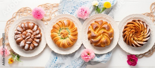 Traditional Romanian sweet bread cozonac sliced, served on flower-decorated plates on a concrete table. Springtime Easter baking. Healthy holiday food. Top view photograph of excellent quality.