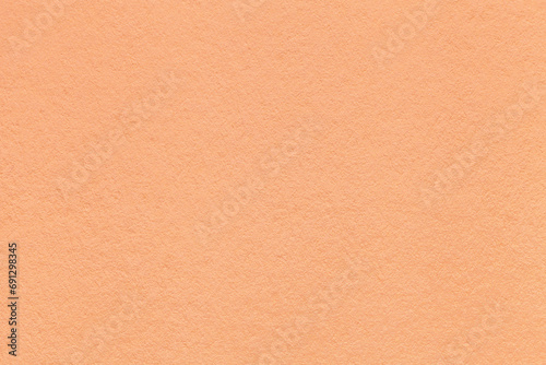 Color of the year 2024 peach fuzz. Texture of coral colors paper background, macro. Structure of craft cardboard. photo
