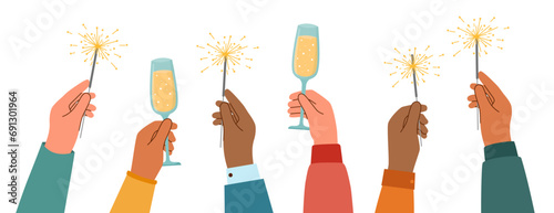 Human hands with sparklers and champagne flutes raised upwards. Celebration concept. 