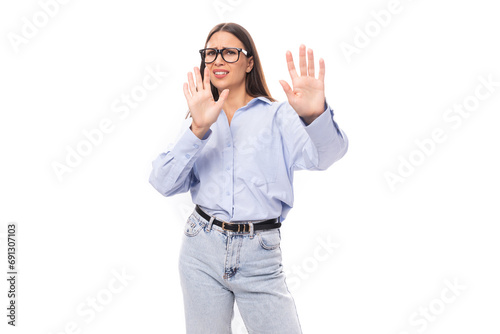 young pretty european brunette business woman with light makeup in a light blue blouse wears glasses for an image to work on a white background with copy space