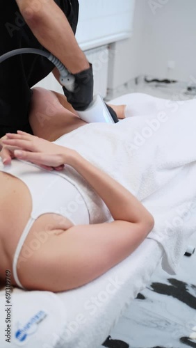 Endospheres therapy session underway, targeting cellulite and enhancing lymphatic drainage. Therapist applies massager on relaxed client, improving circulation, skin tone in aesthetic clinic. photo