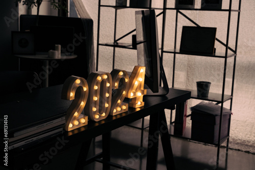 2024 sign lit up in the dark room.
