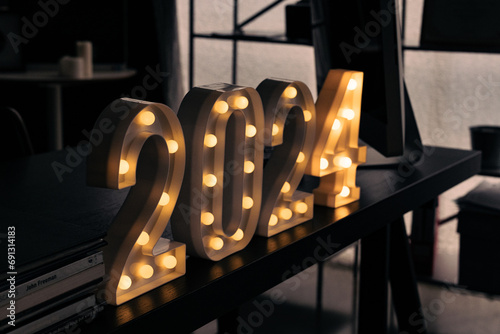 2024 sign lit up in the dark room.
