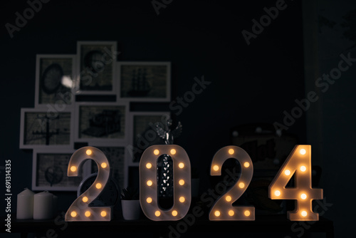 2024 sign lit up in the dark room.
