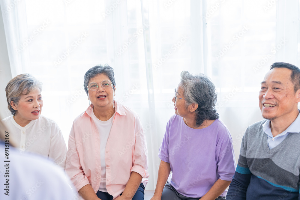 senior females and male sitting on bench. older people are listening and enjoy meeting focus group at living room. Joyful carefree retired senior friends enjoying relaxation at nearly home.