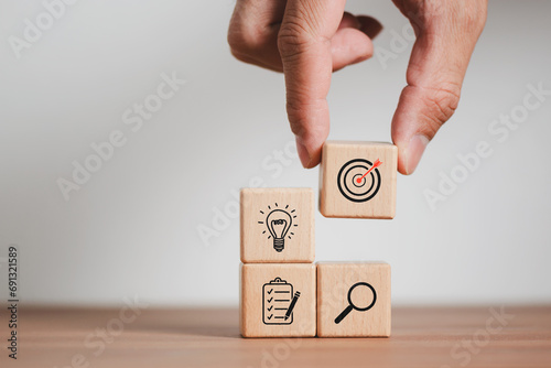 Businessman in selecting Wood cube block stacking with icon. business strategy and action plan Concept.