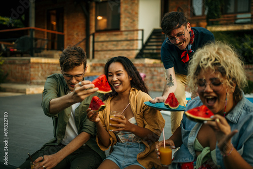 Inclusive group of friends chilling in the backyard  surrounded by nature  enjoying fruits and tasty cocktails