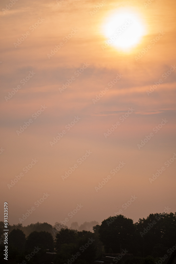 Fototapeta premium Sunset over a field in country