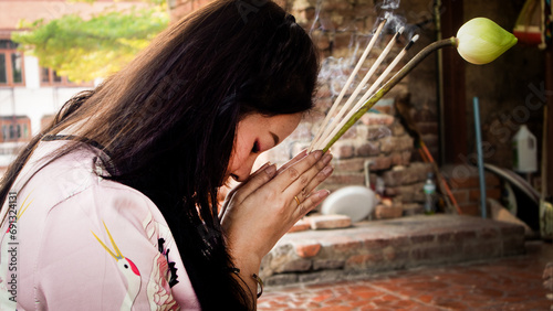 religious asian buddhist woman having worship and pray with faith to buddha statue at temple photo