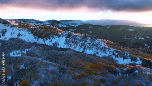 First light Kebler Pass Crested Butte Gunnison Colorado seasons crash aerial drone early fall aspen tree red yellow orange forest winter first snow cold sunrise cloud Rocky Mountain peaks left motion photo