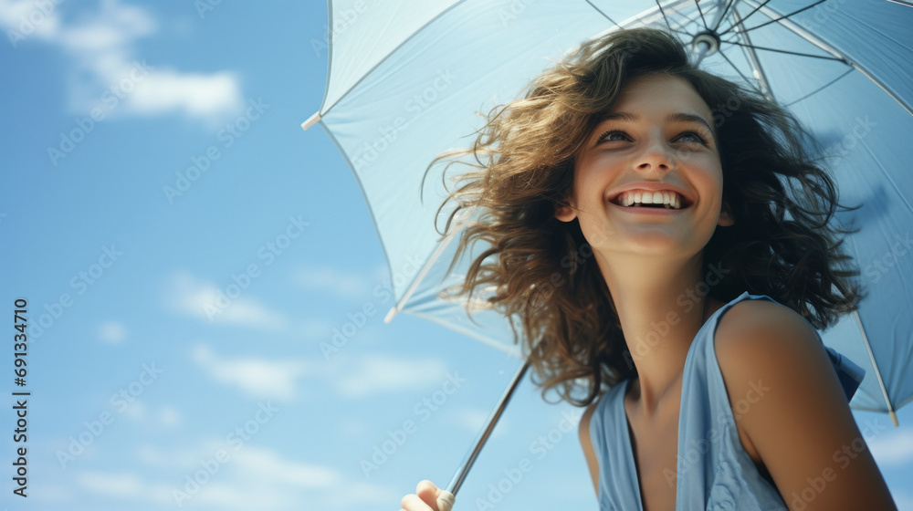 Happy woman with sunny blue sky holding a blue umbrella or sunshade to protect her skin from sun light with return of warm days - obrazy, fototapety, plakaty 