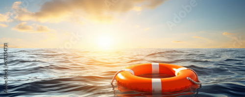 Lifebuoy floating on sea banner background with copy space and hopeful sun rays photo