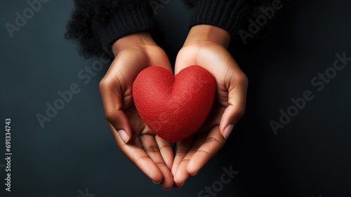 Close-up of African American female hands holding a red heart  a symbol of love