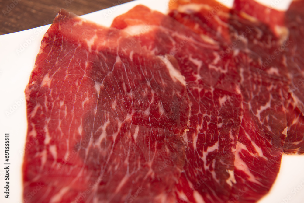Dry-cured Spanish ham, Serrano ham, Bellota ham, Italian prosciutto crudo or Parma ham, wagyu slice. High quality photo Dry-cured Spanish ham, Serrano ham, Bellota ham, Italian prosciutto crudo or Parma ham, wagyu slice. High quality photo