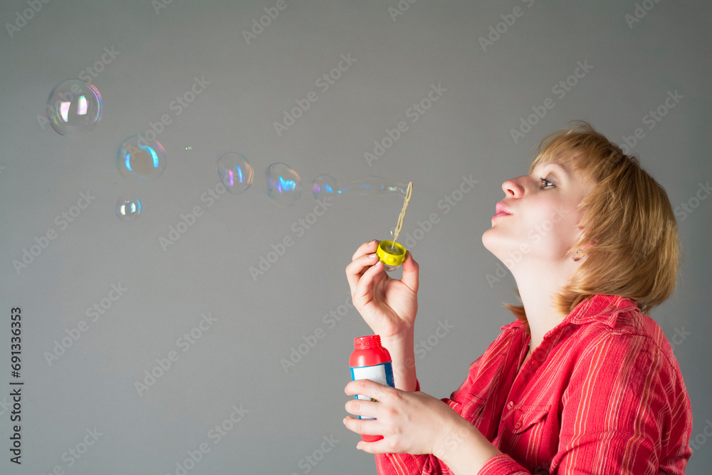 Funny Portrait of Pregnant Woman in Red Shirt Blowing Soap Bubbles As Middle Aged Mother Caring As Healthy Pregnancy Concept On Gray Funny Portrait of Pregnant Woman in Red Shirt Blowing Soap Bubbles As Middle Aged Mother Caring As Healthy Pregnancy Concept On Gray