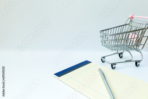 shopping car notebook and pencil isolated