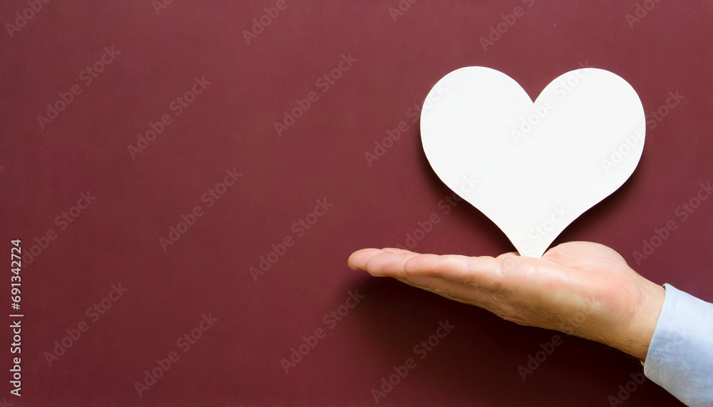Hand holding a heart symbol, copy space on a side Hand holding a heart symbol, copy space on a side