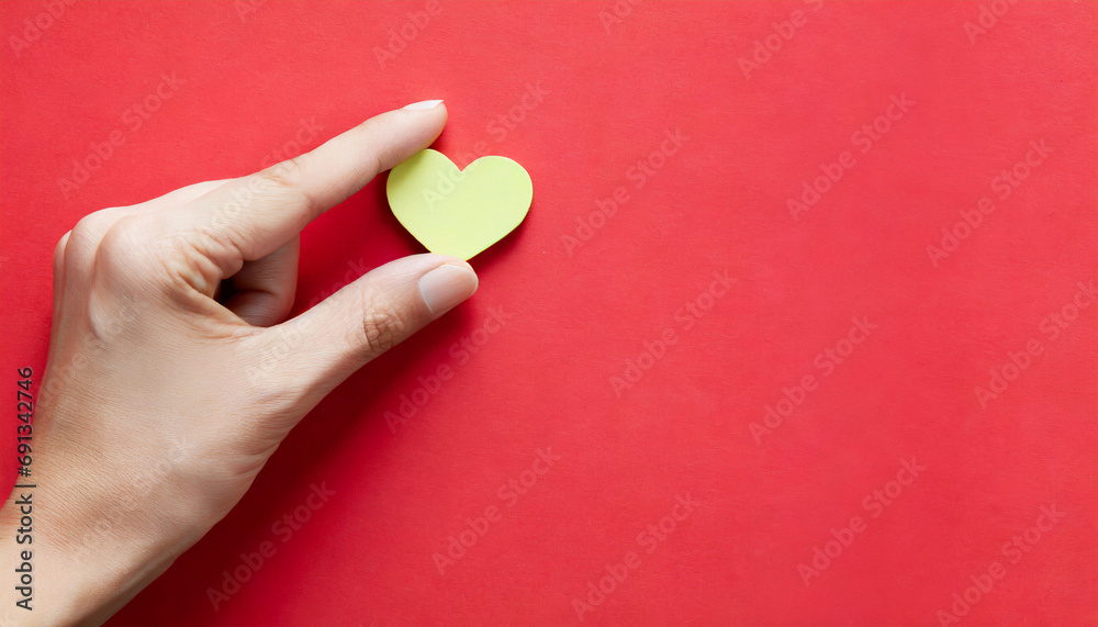 Hand holding a heart symbol, copy space on a side Hand holding a heart symbol, copy space on a side