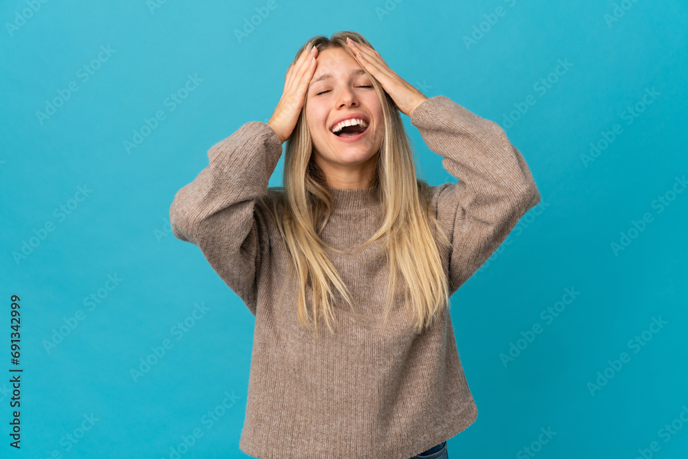 Young blonde woman isolated on blue background laughing Young blonde woman isolated on blue background laughing