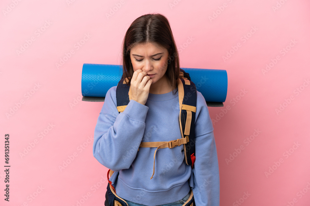 Young mountaineer woman with a big backpack isolated on pink background having doubts Young mountaineer woman with a big backpack isolated on pink background having doubts