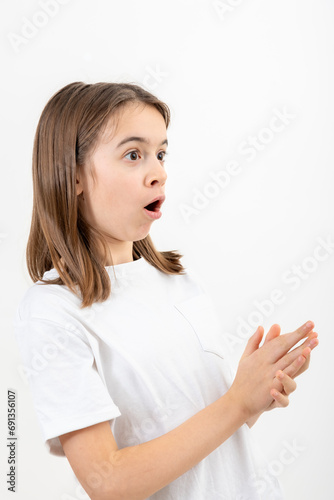 Little girl looks to the side in surprise on a white background isolated.