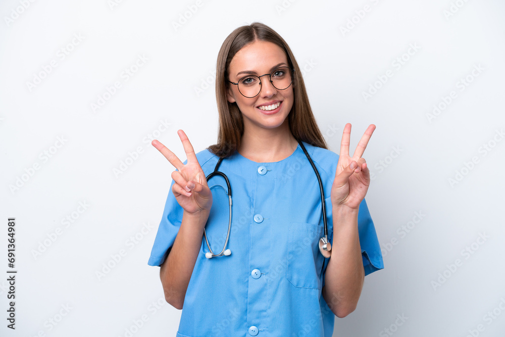 Young nurse caucasian woman isolated on white background showing victory sign with both hands