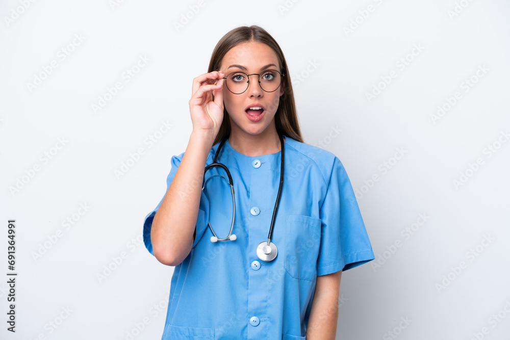 Young nurse caucasian woman isolated on white background with glasses and surprised Young nurse caucasian woman isolated on white background with glasses and surprised