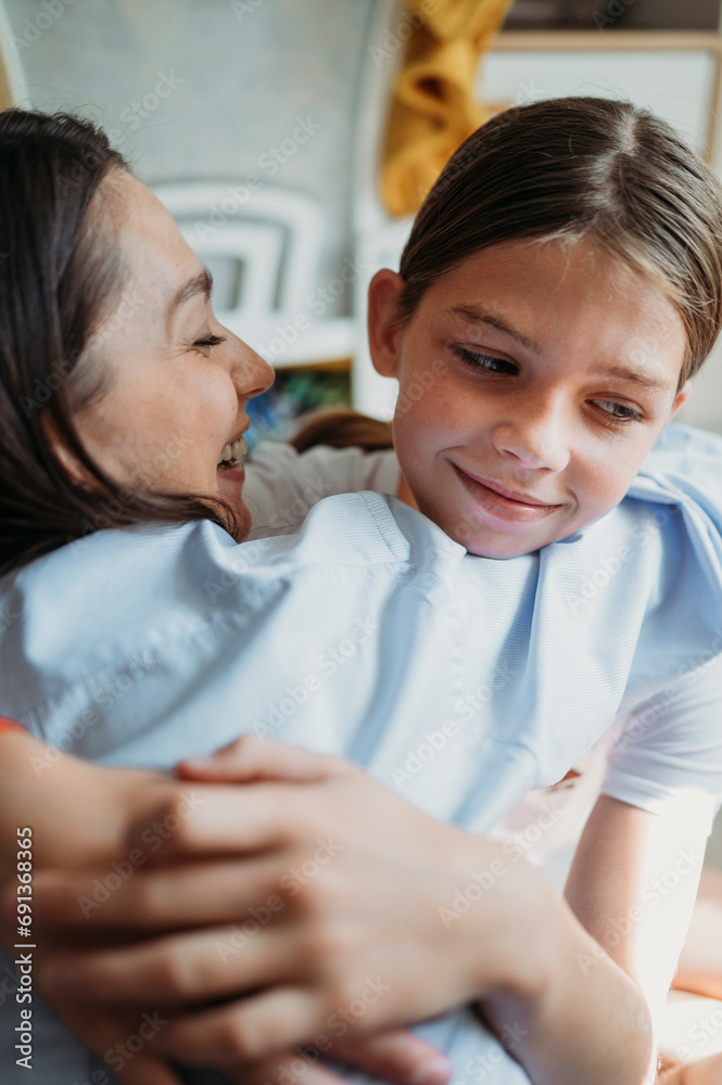 Smiling mother hugging daughter at home Smiling mother hugging daughter at home