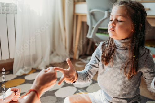 Girl playing rock paper scissors with father at home photo