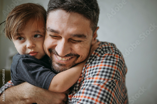 Loving father embracing son at home photo