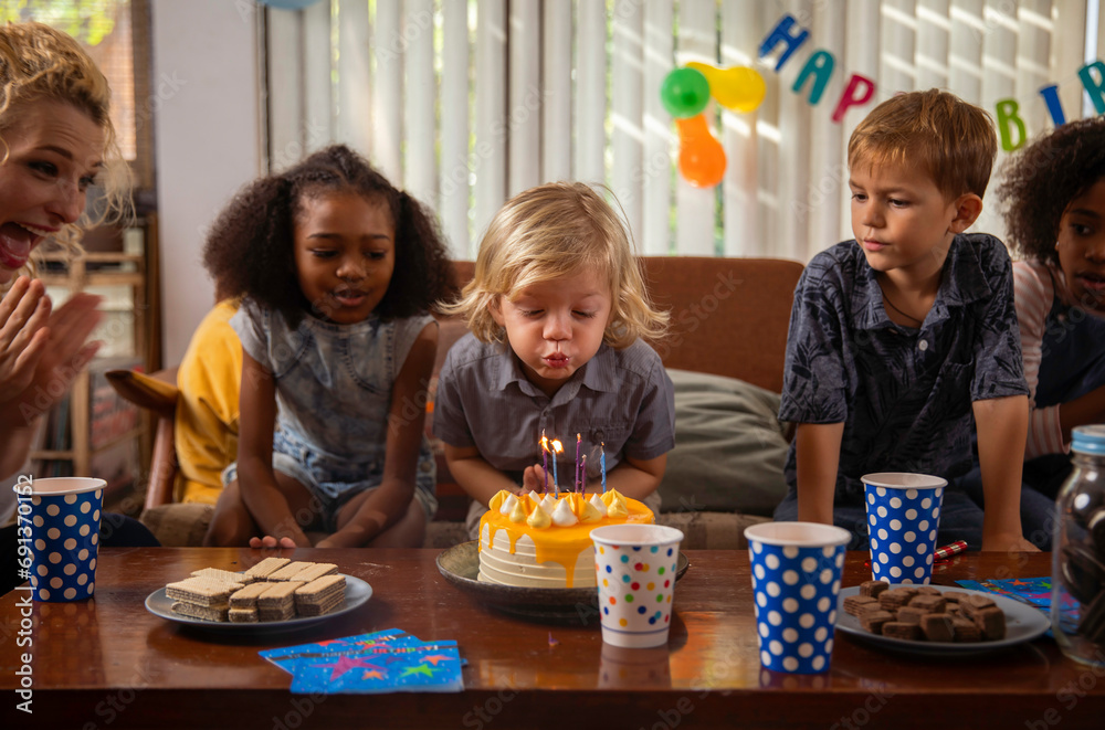 Boy blowing candles on his birthday cake with friends watching Boy blowing candles on his birthday cake with friends watching