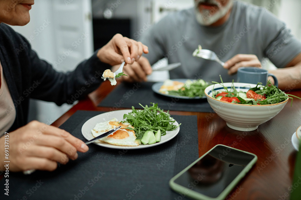 Couple eating fried eggs and salad for breakfast at home Couple eating fried eggs and salad for breakfast at home